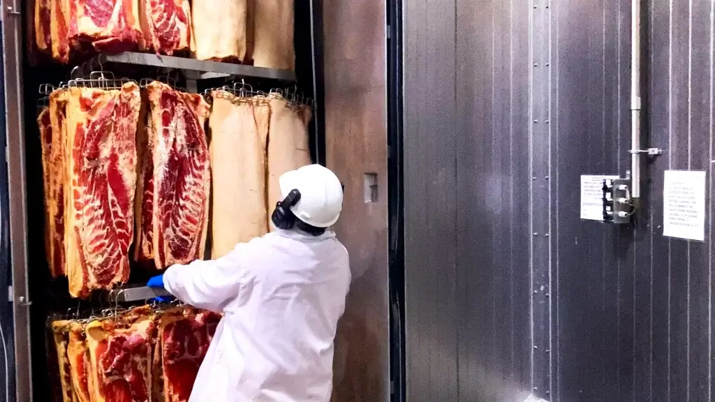 Man Standing In Front Of Cut Of Meat