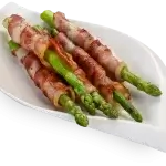 Bacon wrapped asparagus placed on a plate